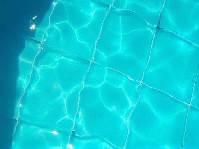 Close-up of vibrant blue and green artisan ceramic tiles for a pool.
